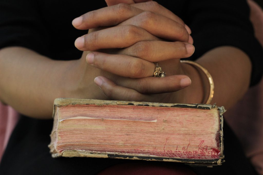 praying hands on Bible